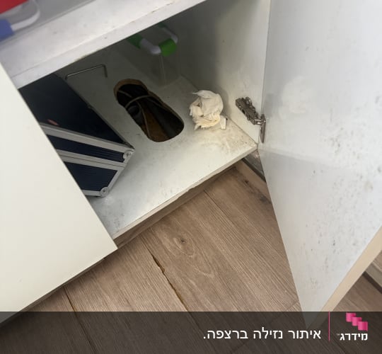 ארון פתוח עם צינורות ונייר טואלט